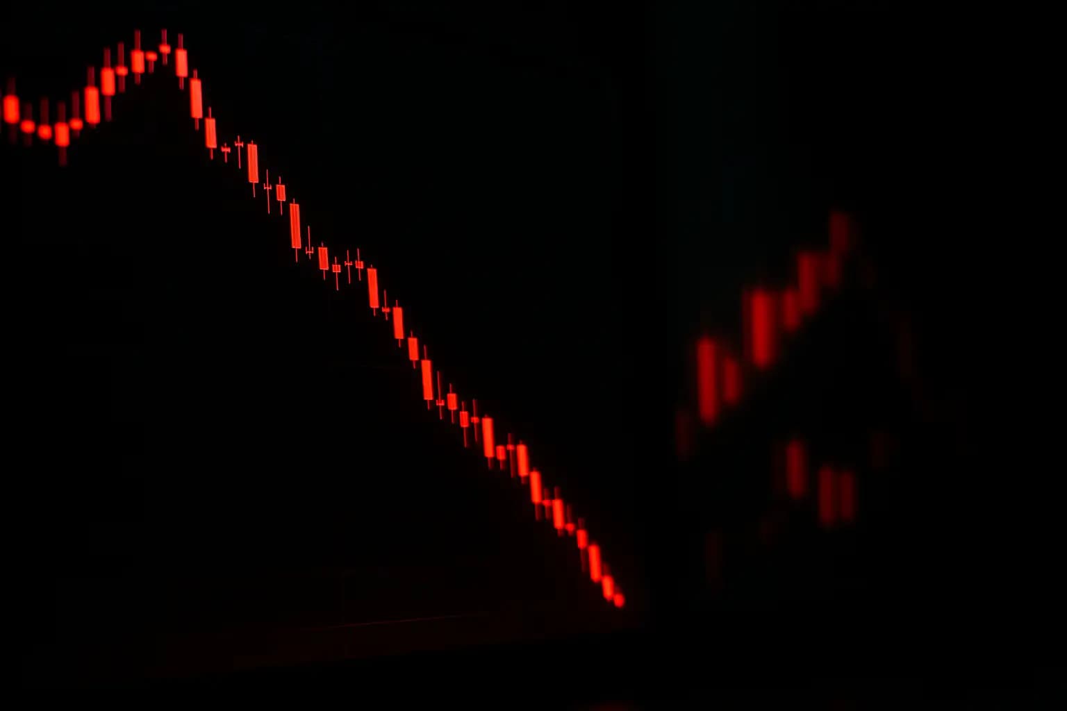 A red declining price chart on a digital trading screen with Bitcoin symbol visible